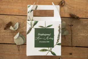 Quadratische Hochzeitstortenbox. Grüner Zweig vor dem Hintergrund von Flaschengrün.