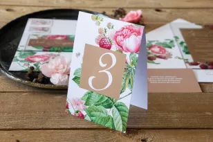 Nummern von Hochzeitstischen mit Pfingstrosen und Himbeeren, umgeben von einer zarten, cremefarbenen Farbe