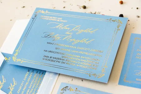 Eleganckie zaproszenia ślubne ze złoconą ramką. Zaproszenie ślubne w kolorze dusty blue z kaligrafinczą