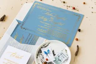 Eleganckie zaproszenia ślubne ze złoconą ramką. Zaproszenie ślubne w kolorze dusty blue z kaligrafinczą