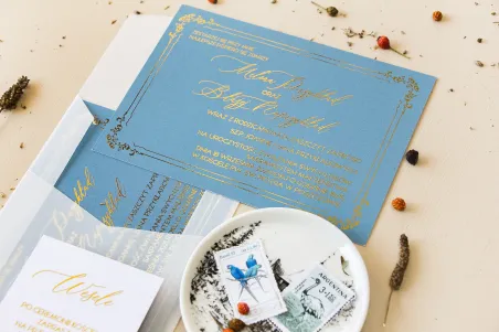 Eleganckie zaproszenia ślubne ze złoconą ramką. Zaproszenie ślubne w kolorze dusty blue z kaligrafinczą