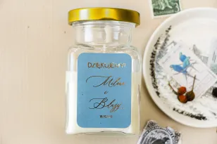 Świeczki - prezenty dla gości weselnych w stylu Glamour. Etykieta w kolorze dusty blue z kaligrafinczą, złotą czcionką.