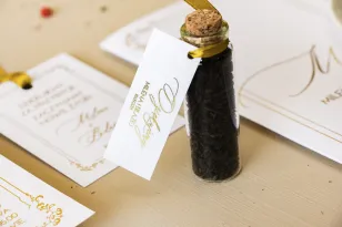 Geschenke für Gäste in Form von Teeflaschen. Minimalistisches Etikett in weißer Farbe mit Vergoldung