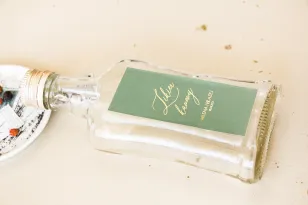Hochzeitsflaschen für Tinkturen, Geschenke für Gäste. Etikett mit einer Dominanz von grünem und goldenem Rahmen