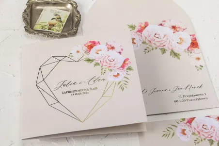 Cremige Hochzeitseinladungen mit einem goldenen, geometrischen Herz und einem Strauß pastellfarbener Blumen