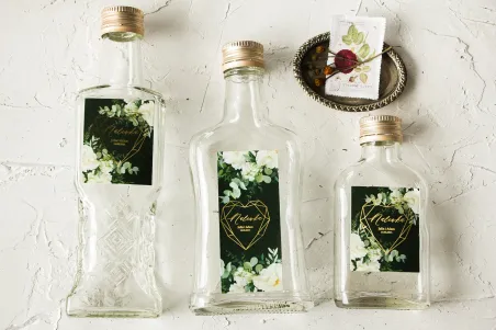 Ślubne Butelki na nalewki wraz ze złoconą etykietą w kolorze butelkowej zieleni z dodatkiem białych piwonii
