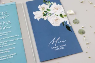 Hochzeitsmenü für die Hochzeitstafel mit weißen Pfingstrosen und Rosen, staubiges Blau mit weißer Schrift.