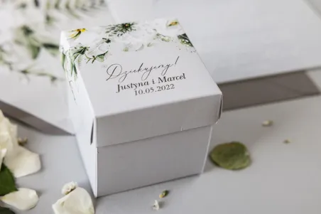 Eine Schachtel für Süßigkeiten für Hochzeitsgäste in Form eines Würfels mit Astern und weißen Blumen