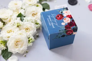 Eine Schachtel für Süßigkeiten für Hochzeitsgäste in Form eines Würfels mit einer Komposition aus burgunderroten und rosa