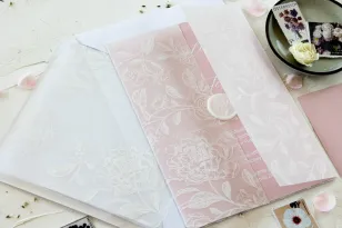 Zarte Hochzeitseinladungen in puderrosa Farbe, weißer Pfingstrosendruck auf der Verpackung