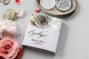 Dank der Hochzeitsgäste in Form von Milchschokolade, Verpackung im minimalistischen Stil mit Grafiken von goldenen Pfingstrosen.