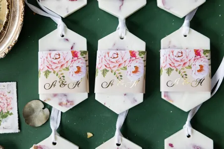 Duftender Sojaanhänger als Dankeschön an die Hochzeitsgäste, cremiges Deckblatt mit einem Strauß pastellfarbener Blüten
