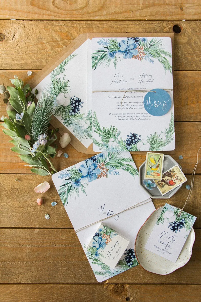 Zimowe zaproszenia ślubne z motywem bawełny, piernika i niebiesko-zielonych gałązek