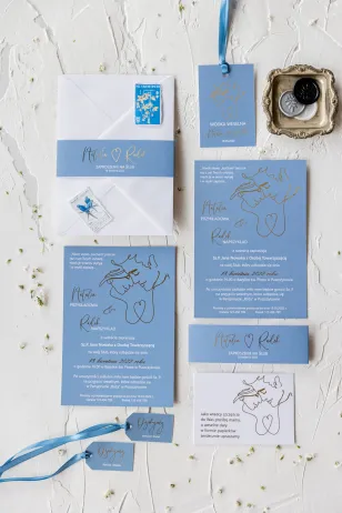 Minimalistyczne zaproszenia ślubne w kolorze dusty blue. Złote detale podkreślają unikatowy charakter zaproszenia
