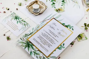 Zaproszenia ślubne w stylu glamour z botanicznym motywem greenery – zielone gałązki w otoczeniu złotej ramki oraz tekstu