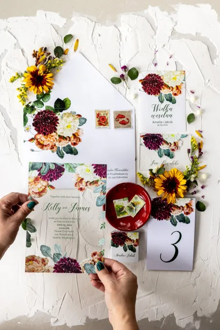 Herbstliche Hochzeitseinladungen mit weinroten Dahlien und Teerosen auf Glas