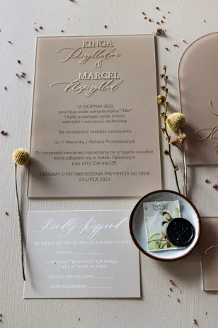 Moderne Hochzeitseinladungen auf beigefarbenem Glas mit vergoldeten Vor- und Nachnamen des Brautpaares
