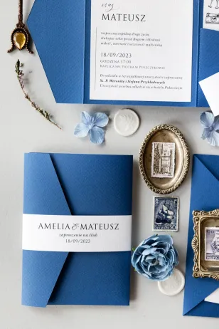 Niebieskie Zaproszenia Ślubne w etui z kiesznką na bilecik oraz owijką od Amelia-Wedding.pl