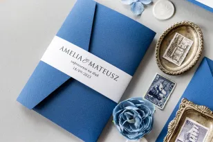 Niebieskie Zaproszenia Ślubne w etui z kiesznką na bilecik oraz owijką od Amelia-Wedding.pl