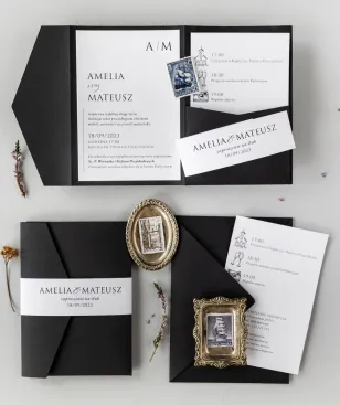 Schwarze Hochzeitseinladungen im Etui mit einer Tasche für ein Ticket und einer Verpackung von Amelia-Wedding.pl