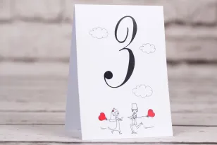 Hochzeitsnummern von Hochzeitstischen aus der Bueno-Kollektion Nr. 5 - Zeichnung des Brautpaares mit roten Luftballons, die