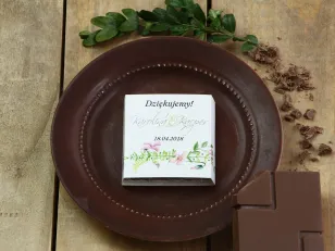 Dank der Hochzeitsgäste in Form von Milchschokolade, Verpackung mit Grafiken aus Pastellveilchen und einem grünen Zweig