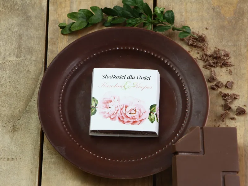 Podziękowanie dla gości weselnych w postaci mlecznej czekoladki, owijka z grafiką róż i zielonych liści