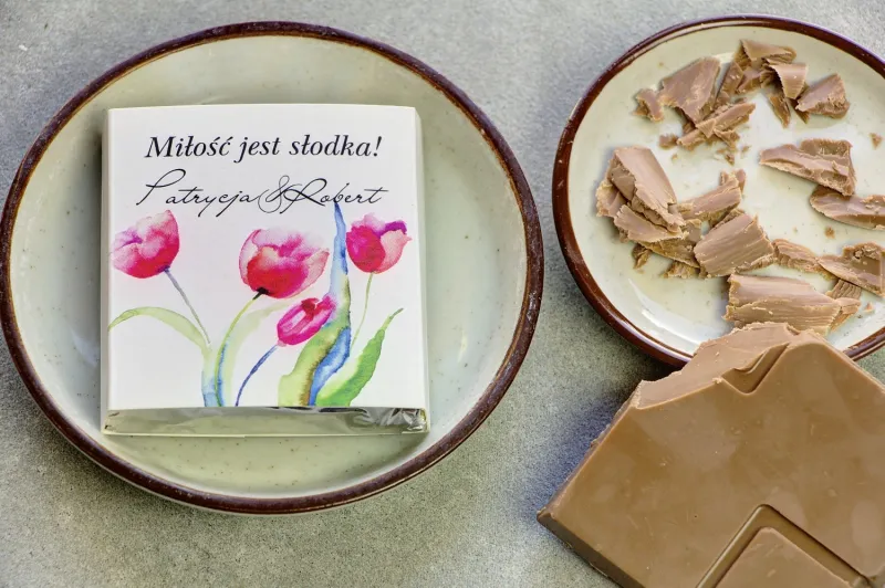 Podziękowanie dla gości weselnych w postaci mlecznej czekoladki, owijka z czerwonymi tulipanami