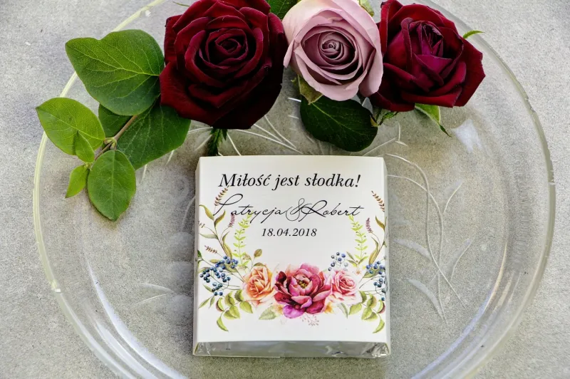 Podziękowanie dla gości weselnych w postaci mlecznej czekoladki, owijka z bordowymi i pudrowymi różami