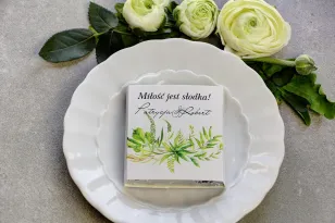 Dank der Hochzeitsgäste in Form von Milchschokolade, Verpackung mit grüner Komposition zu einem zarten Kranz kombiniert