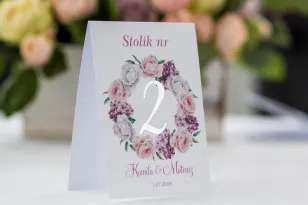 Numery stolików weselnych ze srebrzeniem. Wianek z białymi i różowymi piwoniami oraz kwiatami bzu