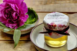Süße Geschenke für Hochzeitsgäste in Form von Gläsern mit Honig. Herbst-Winter-Kombination von Dahlienblüten
