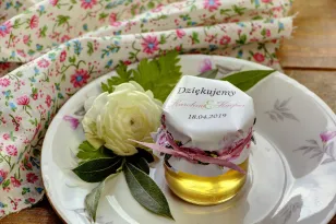 Süße Geschenke für Hochzeitsgäste in Form von Gläsern mit Honig. Zarte, blassrosa Rosen