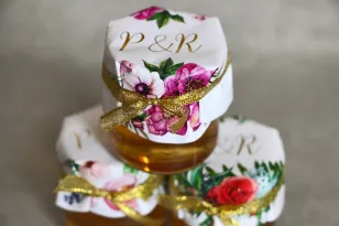 Glas Honig - ein süßes Dankeschön an die Hochzeitsgäste. Vergoldete Initialen. Kombination aus weißen und violetten Anemonen