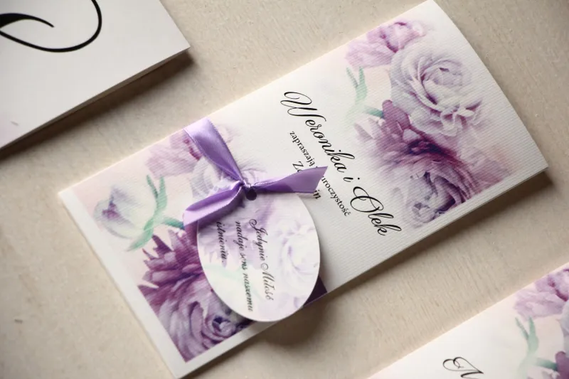 Zaproszenia ślubne z fioletowymi piwoniami z ozdobną przywieszką z wierszykiem.