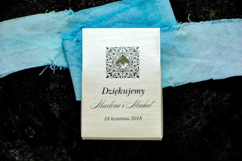 Pudełeczko na słodkości jako podziękowania dla gości na papierze perłowym z fakturą, ornamentem oraz przezroczystym kamyczkiem Pudełeczko na słodkości jako podziękowania dla gości na papierze perłowym z fakturą, ornamentem oraz przezroczystym kamyczkiem
