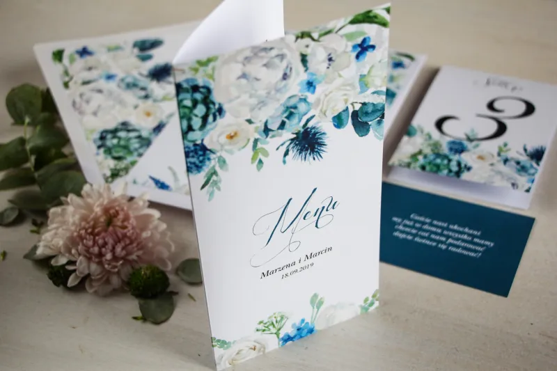 Niebieskie Menu weselne, grafika z białymi różami z dodatkiem zielonych i niebieskich liści