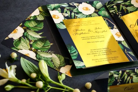 Granatowe zaproszenia ślubne w stylu glamour ze złotą ramką z białą kamelią i dodatkiem zielonych liści