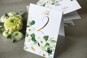 Biało-zielone Numery stołów weselnych ze złoconymi gałązkami w stylu glamour, motyw delikatnych, białych kwiatów i zieleni
