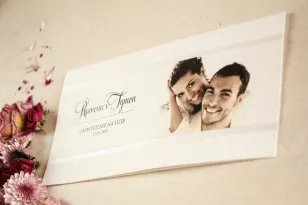 Hochzeitseinladungen mit einem Foto im DL-Format auf Papier mit zarter Textur zusammen mit Perlenpapier.
