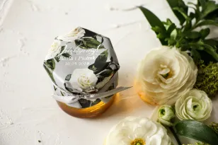 Ein Glas Honig dank der Hochzeitsgäste. Käppchen mit weißen Rosen im Glamour-Stil