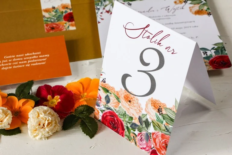 Numery stolików weselnych z pomarańczowymi i amarantowymi różami