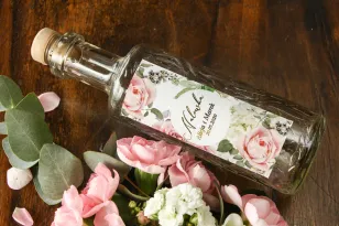 Butelki na nalewki wraz z etykietą w stylu glamour z dodatkiem pudrowych róż oraz białej hortensji