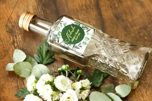 Butelki na nalewki wraz z etykietą z eukaliptusem i gipsówką. Etykiety nawiązują do motywu greenery oraz glamour