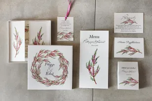 Probeset mit Hochzeitseinladungen in einer Schachtel mit Kranz und Heidekraut.