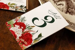 Hochzeitstischnummern mit roter Rose und grünen Zweigen mit dem Zusatz von Weiß
