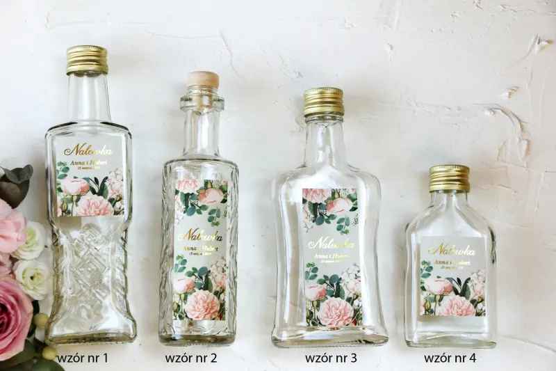 Ślubne Butelki na nalewki wraz ze złoconą etykietą oraz z eleganckim bukietem z drobnych, pudrowych róż i białych hortensji