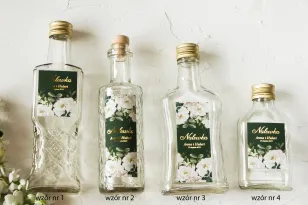 Hochzeitstinkturflaschen mit vergoldetem Etikett und einem eleganten Bouquet aus weißen Rosen und Pfingstrosen mit Eukalyptuszus