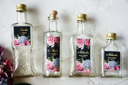 Szklane butelki z niebieskimi hortensjami i różowymi piwoniami | Oryginalne prezenty weselne dla gości