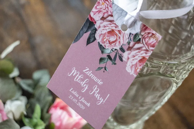 Zawieszki na butelki weselne w kolorze pudrowego różu z kompozycją z białych i różowych piwonii i róż